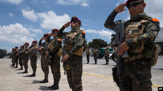 Soldados en la base de la fuerza aérea en Ciudad de Guatemala saludan la llegada de los restos de tres de sus camaradas que murieron en enfrentamientos con presuntos narcotraficantes. AP/Moisés Castillo. Septiembre 5 de 2019. AP