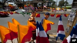 Warga berjalan di sebelah bendera Kosta Rika dan bendera-bendera partai politik, di San Jose, Sabtu, 5 April 2014.