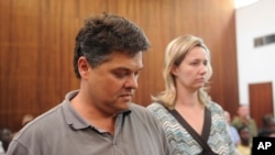 FILE - Game farmer Dawie Groenewald, left, and his wife, Sariette, right, appear in court in Musina, South Africa, Wednesday, Sept 22, 2010.