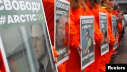 FILE - Greenpeace activists hold portraits of those detained on the boat Arctic Sunrise during a rally in Moscow, Russia.