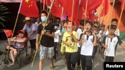 Villagers including schoolchildren take part in a protest march, demanding the release of their village chief Lin Zulian, in Wukan, in China's Guangdong province, June 21, 2016. (REUTERS/James Pomfret )