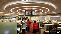 Floor traders walk inside the trading hall of the Hong Kong Stock Exchange, March 2, 2011