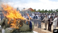 Cambodian officers burn some three tones of various drugs are seized in the nation wide of this country at the outskirt of Phnom Penh, Cambodia, Tuesday, June 2, 2009. 