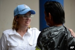 Mayor Carmen Yulin Cruz speaks with a man as she arrives at a hospital in the Rio Piedras area of San Juan, Puerto Rico, Sept. 30, 2017.