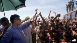 A Bangladeshi officer tries to calm Rohingya refugees during a protest against repatriation at Unchiprang refugee camp near Cox's Bazar, in Bangladesh, Thursday, Nov. 15, 2018. (AP Photo/Dar Yasin)