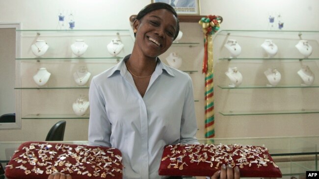 Une hôtesse ghanéenne présente des bijoux en or le 1er février 2008 dans les locaux de la Commission des minéraux, gérée par l'État, à Accra.