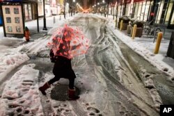 A woman crosses a street during a winter storm in Philadelphia, March 14, 2017.