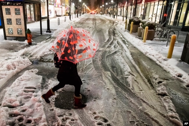 A woman crosses a street during a winter storm in Philadelphia, March 14, 2017.