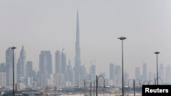 The skyline is seen with the Burj Khalifa as ships dock at Port Rashid, in Dubai, May 26, 2013. 