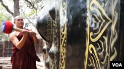 A Myanmar monk ringing a giant gong. (Z. Aung/VOA)