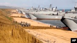 FILE - This frame from a video released on April 23, 2021, by the Russian Defense Ministry Press Service shows Russian troops board landing vessels after drills in Crimea. Russia annexed the peninsula from Ukraine in 2014.