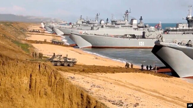 FILE - This frame from a video released on April 23, 2021, by the Russian Defense Ministry Press Service shows Russian troops board landing vessels after drills in Crimea. Russia annexed the peninsula from Ukraine in 2014.