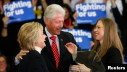 Kandidat presiden AS dari Partai Demokrat Hillary Clinton, bersama suaminya Bill dan putri mereka Chelsea dalam kampanye di New Hampshire, Februari.