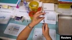 A healthcare worker prepares a dose of the Pfizer coronavirus disease vaccine at a vaccination centre in Seixal, Portugal, September 11, 2021. 