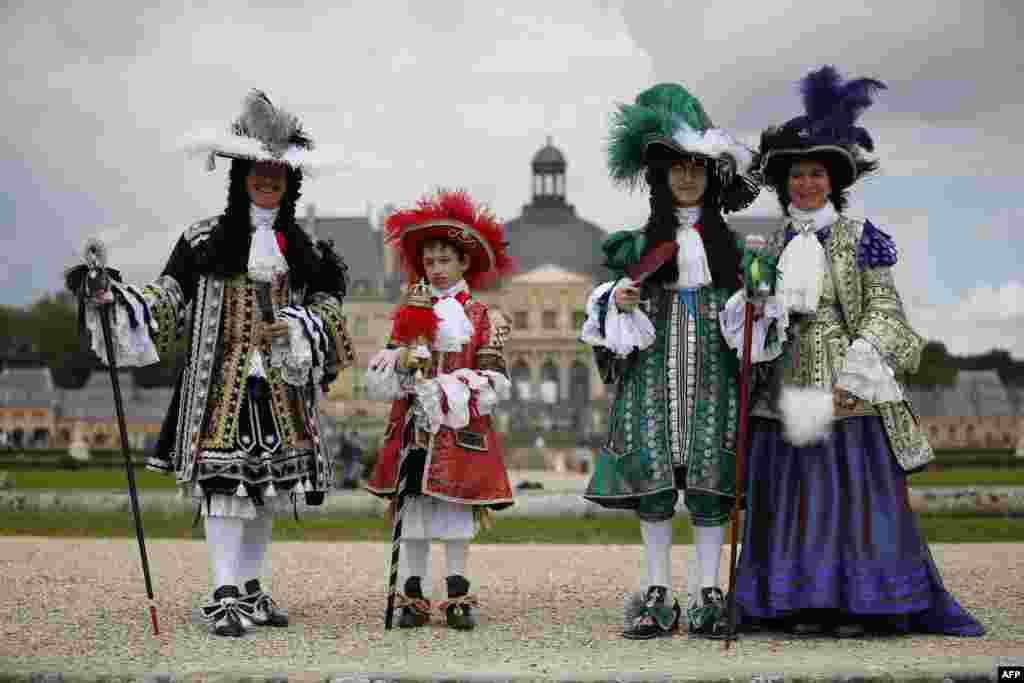 Warga yang mengenakan pakaian tradisional, berpose di kastil Chateau de Vaux-le-Vicomte di Maincy dekat Paris, Perancis.