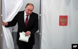 Russian President and Presidential candidate Vladimir Putin exits a polling booth as he prepares to cast his ballot during Russia's presidential election in Moscow, Russia, March 18, 2018.