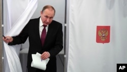 푸틴 러시아 대통령이 18일 대선 투표를 위해 기표소를 나오고 있다.
