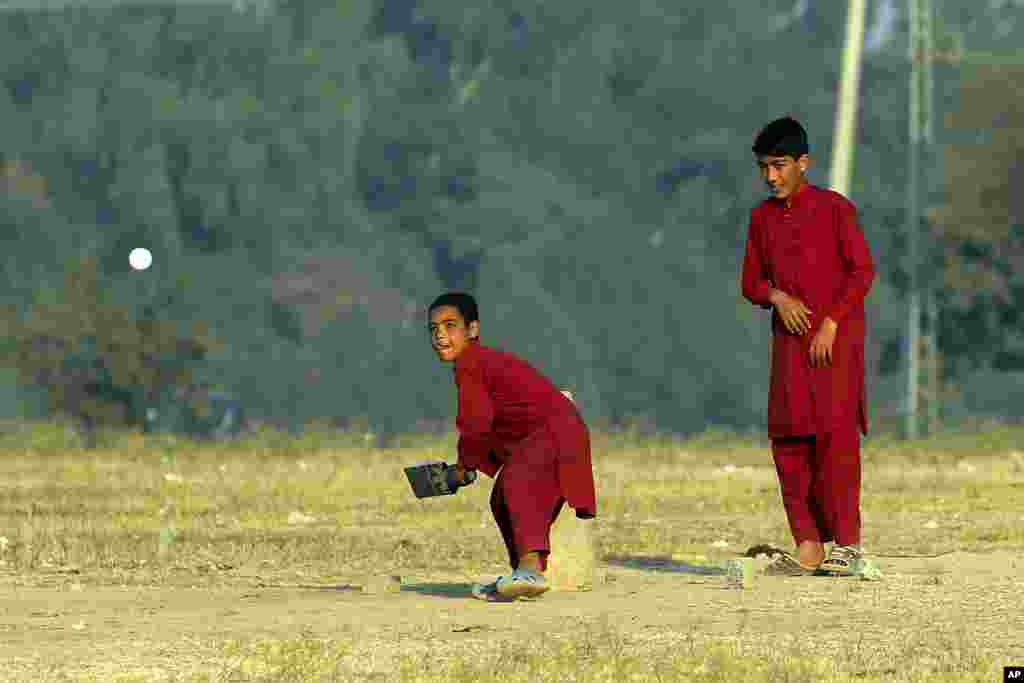 Boys plays cricket on the outskirts of Islamabad. 