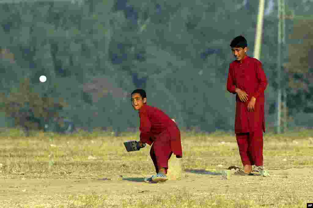 Boys plays cricket on the outskirts of Islamabad.