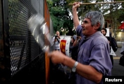 A demonstrator hits a police fence during a protest against the visit by U.S. President Barack Obama to Argentina, outside the U.S. Embassy in Buenos Aires, March 23, 2016.