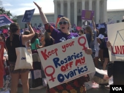 Pro-choice demonstrators wave signs and make their voices heard after the Supreme Court upheld abortion rights in a 5-3 decision, in front of the Supreme Court building in Washington, June 27, 2016. (J. Oni / VOA News)
