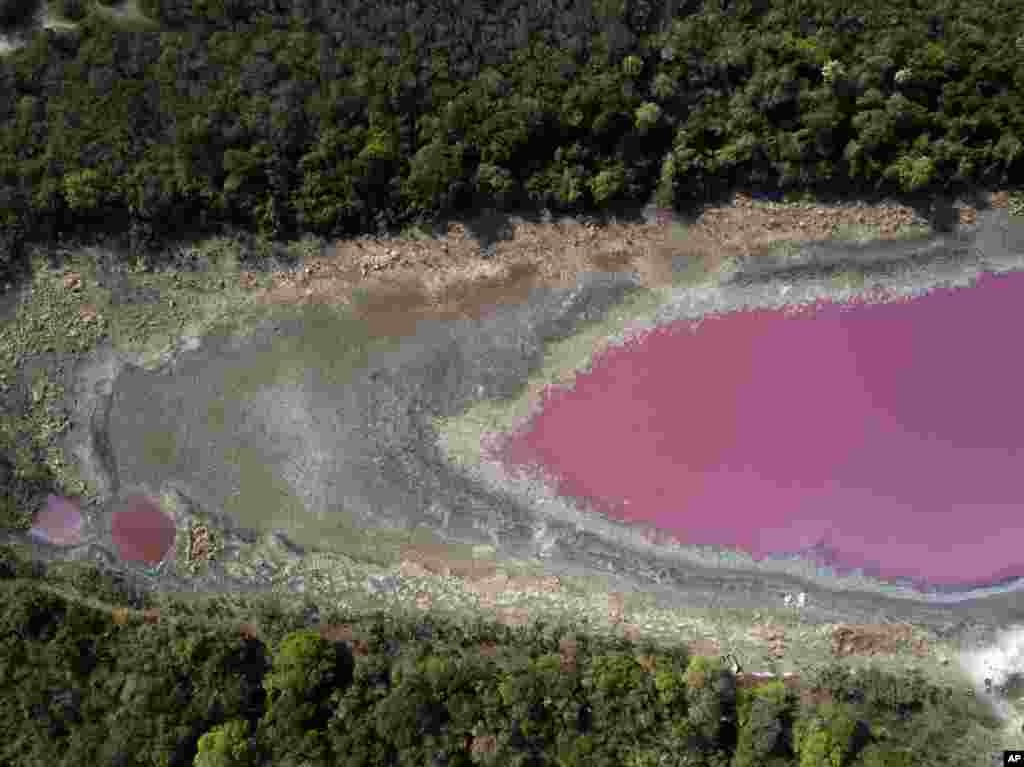 The bed of the Cerro Lagoon is dry and cracked from an extended drought, holding purple water due to untreated waste from a tannery company, in Limpio, which means "clean," Paraguay, Wednesday, Oct. 21, 2020. The Environment Ministry has proposed the Walt