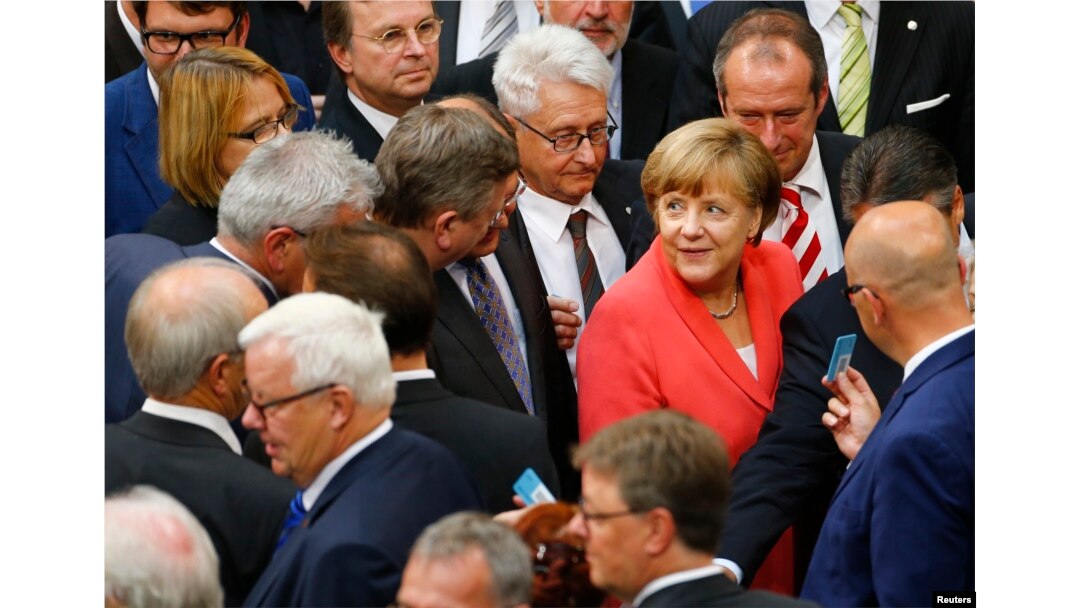 FILE - German Chancellor Angela Merkel prepares to vote during the session of Germany's parliament, the Bundestag, in Berlin, July 17, 2015.