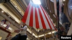 A shopper walks past a 100-foot U.S. flag that will be on display to honor veterans until July 4th, in a department store in Chicago, Illinois, May 23, 2014. 