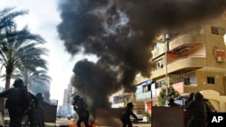 Pasukan keamanan Mesir bentrok dengan pendukung presiden yang digulingkan Mohamed Morsi di Kairo, 10 Januari 2014. 