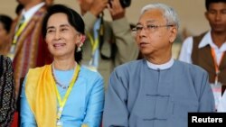 FILE - Myanmar State Councilor Aung San Suu Kyi and Myanmar's President Htin Kyaw attend a photo opportunity after the opening ceremony of the 21st Century Panglong Conference in Naypyitaw, Myanmar, May 24, 2017. 