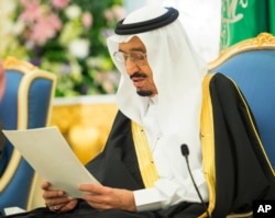 In this photo provided by the Saudi Press Agency, Saudi King Salman delivers his first major policy speech since assuming the throne in the al-Yamama palace, Riyadh, Saudi Arabia, March 10, 2015.