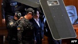 Former director of the Colombian Security Department (DAS) Maria del Pilar Hurtado (C) arrives under custody at the Supreme Court for the reading of her sentence for espionage in Bogota, April 30, 2015.