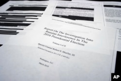 FILE - Four pages of special counsel Robert Mueller report on the witness table in the House Intelligence Committee hearing room on Capitol Hill, in Washington, April 18, 2019.
