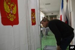 A polling station official checks vote cabins for the 2018 Russian presidential election in Simferopol, Crimea, March 17, 2018.
