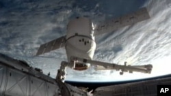 FILE - An image provided by NASA-TV shows the SpaceX Dragon commercial cargo craft as it is backed away from the International Space Station March 26, 2013 by the International Space Station's Canadarm2 robotic arm.