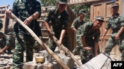 Rescuers help villagers dismantle damaged walls after a shallow 6.4-magnitude earthquake hit the area in Pishan county in Hetian, northeast China's Xinjiang region, July 3, 2015. 