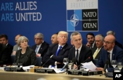 From left, British Prime Minister Theresa May, U.S. President Donald Trump and NATO Secretary General Jens Stoltenberg listen to Belgian Prime Minister Charles Michel as he speaks during a working dinner meeting at the NATO headquarters during a NATO summ