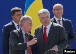 U.S. President Donald Trump's national security adviser John Bolton, front left, and Ukrainian President Petro Poroshenko attend a military parade marking Ukraine's Independence Day in Kyiv, Ukraine, Aug. 24, 2018.