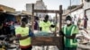 Des employés municipaux portant des masques comme mesure préventive contre le coronavirus nettoient les étals d'un marché informel au quartier populaire de la Médina à Dakar, le 22 mars 2020. (Photo: JOHN WESSELS / AFP)