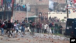 Protestors throw stones during a clash between communities while protesting against Thursday's attack on a paramilitary convoy that killed at least 40 in Kashmir, in Jammu, India, Friday, Feb. 15, 2019.
