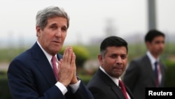 U.S. Secretary of State John Kerry menyapa media ketika tiba di bandara di New Delhi 30 Juli 2014.