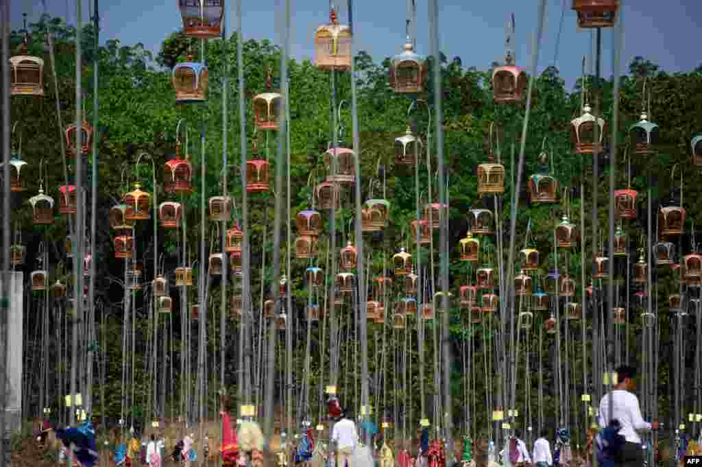 Hanging bird cages are displayed on poles during a bird-singing contest in the Rueso district in Thailand&#39;s southern province of Narathiwat. Hundreds of bird owners from Thailand, Malaysia and Singapore took part in the traditional contest held every year, March 23, 2014.