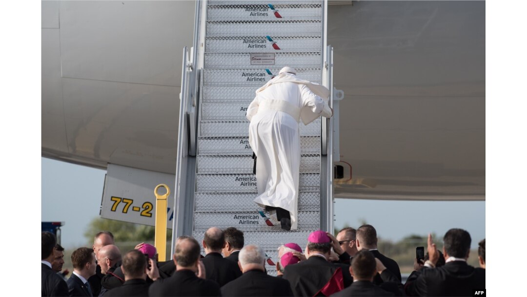 Pope Francis stumbles up the stairs to his flight from New York en route to Philadelphia from John F. Kennedy International Airport in New York, Sept. 26, 2015.
