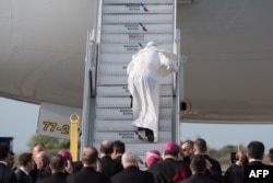 Pope Francis stumbles on the stairs to the aircraft carrying him from New York's John F. Kennedy International Airport to Philadelphia International Airport in Pennsylvania, Sept. 26, 2015.