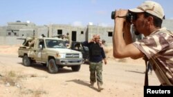 A fighter from forces aligned with Libya's new unity government monitors Islamic State locations at Algharbiyat area in Sirte, June 21, 2016.