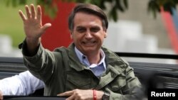 Jair Bolsonaro, far-right lawmaker and presidential candidate of the Social Liberal Party (PSL), gestures at a polling station in Rio de Janeiro, Brazil, Oct. 28, 2018.