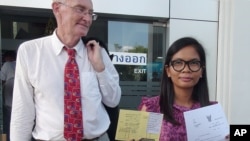 FILE - Alan Morison of Australia, editor of The English-language news website Phuketwan, left, and his Thai colleague, Chutima Sidasathien, right, walk out during a break at Phuket provincial courtroom in Phuket, southern Thailand, Apr. 17, 2014.