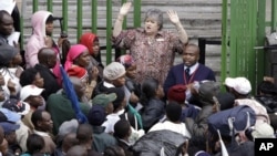 FILE: An immigration official addresses Zimbabweans outside an immigration office in downtown Johannesburg, South Africa, December 15, 2010, as they attempt to become legal. 