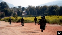 FILE - Myanmar army soldiers carrying weapons patrol on a road as part of operations against ethnic rebels, in Kokang, northeastern Shan State, more than 800 kilometers (500 miles) northeast of Yangon, Myanmar.