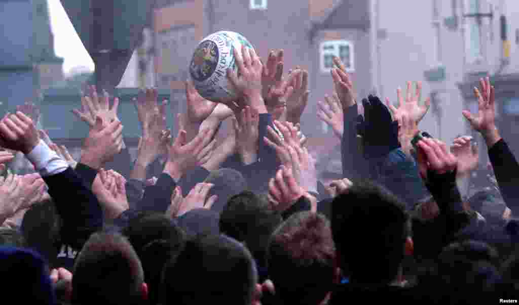 Players try to get the ball during the annual Ashbourne Royal Shrovetide Football match in Ashbourne, Britain.